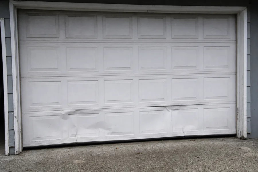 Dented panel sections on an older garage door in New York, NY
