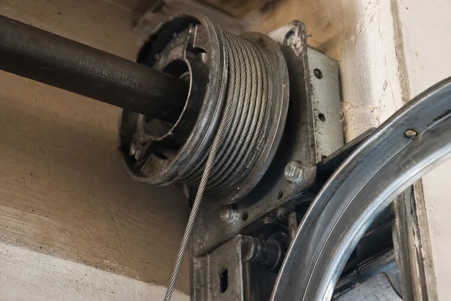 A cable drum at the top of a garage door track in New York, NY