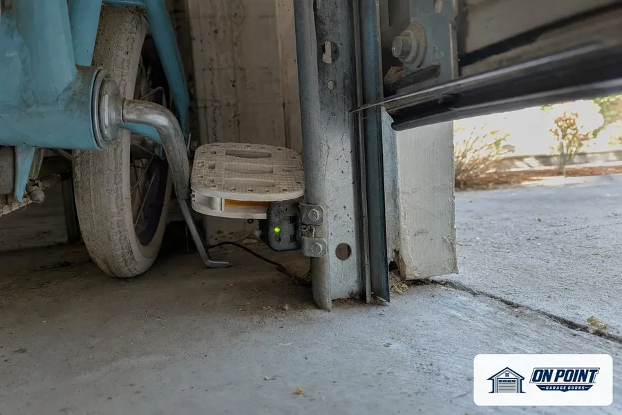 Safety sensor mounted low on the door track next to the bottom roller