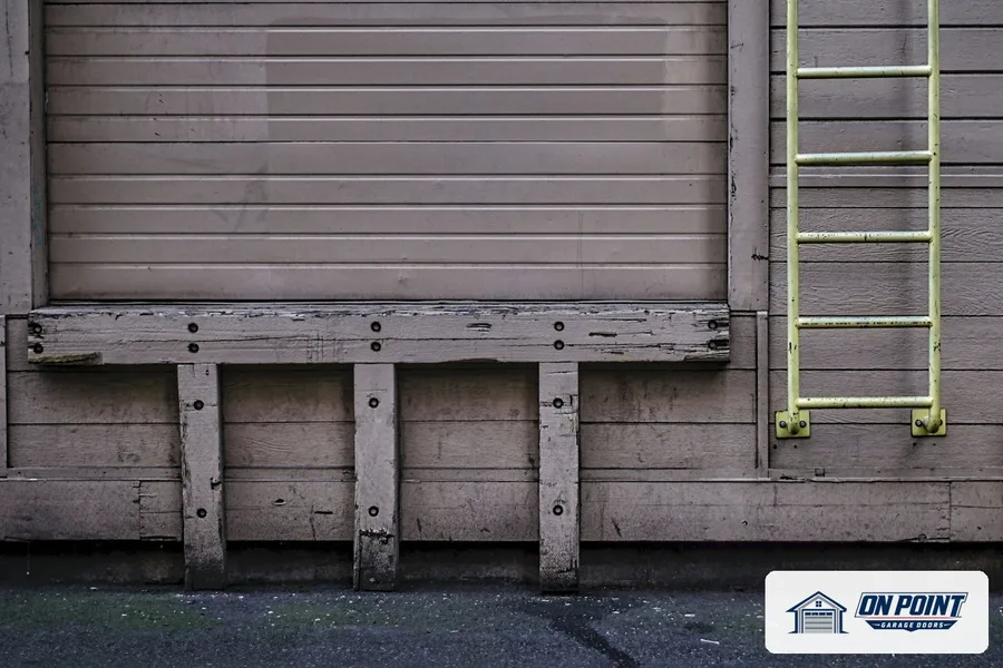 Roll-up door above a timber loading dock with a wall ladder