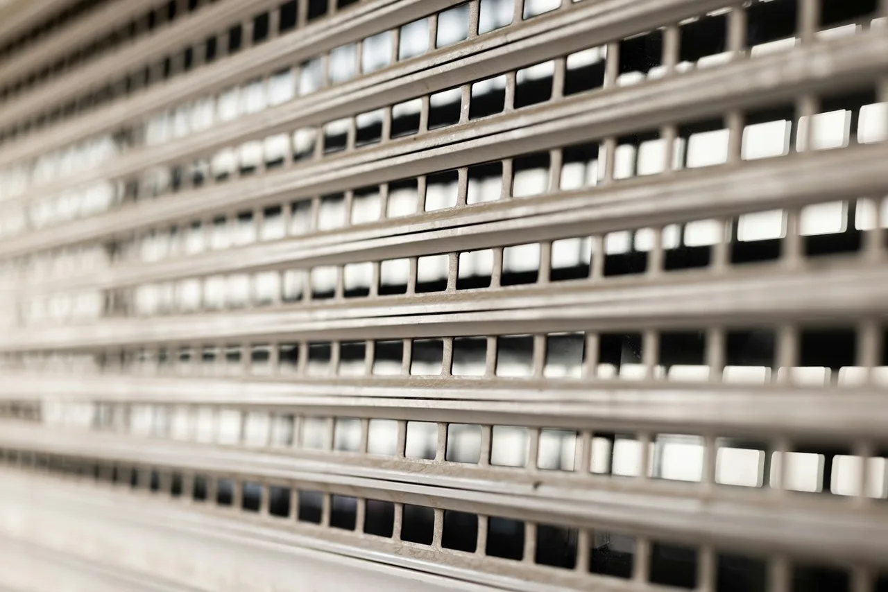 Close-up of perforated rolling gate slats, the see-through kind used on storefront windows