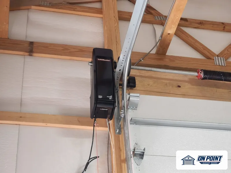 Wall-mount garage door opener installed beside the door